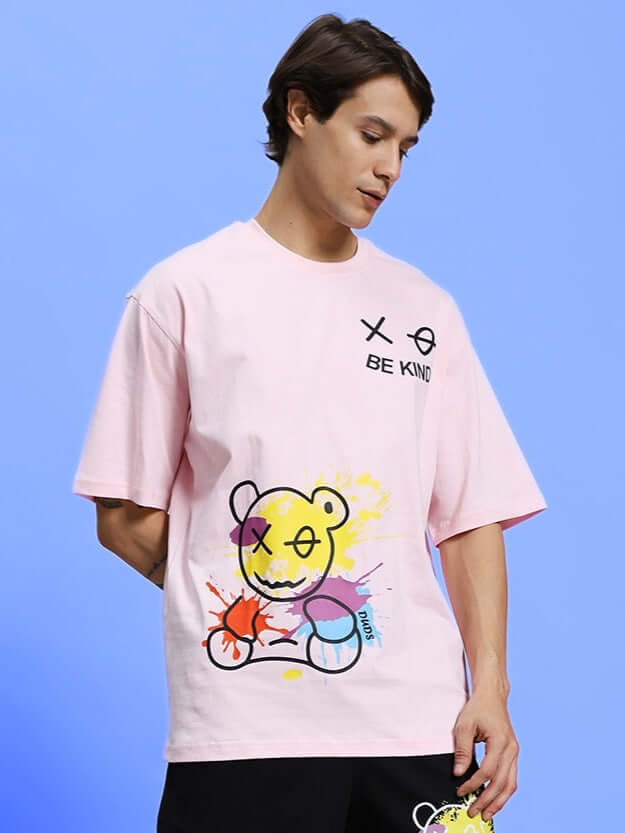 Alt Tag: "Model wearing pink BE KIND over-sized t-shirt with bear graphic, made of premium cotton, by Color By Colours"