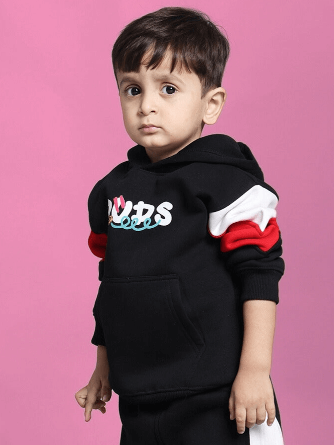 Child wearing DUDS black beanie hoodie for boys & girls, featuring colorful sleeves against a pink background