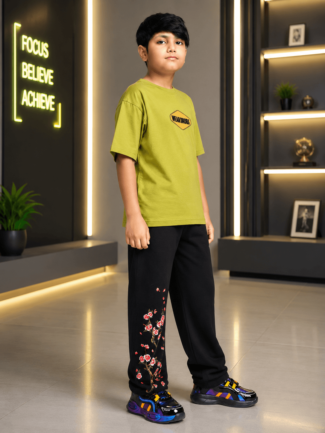 BEAR ON BOARD CO-ORD FOR BOYS GIRLS OLIVE GREEN BLACK outfit on a young boy standing confidently in modern setting.