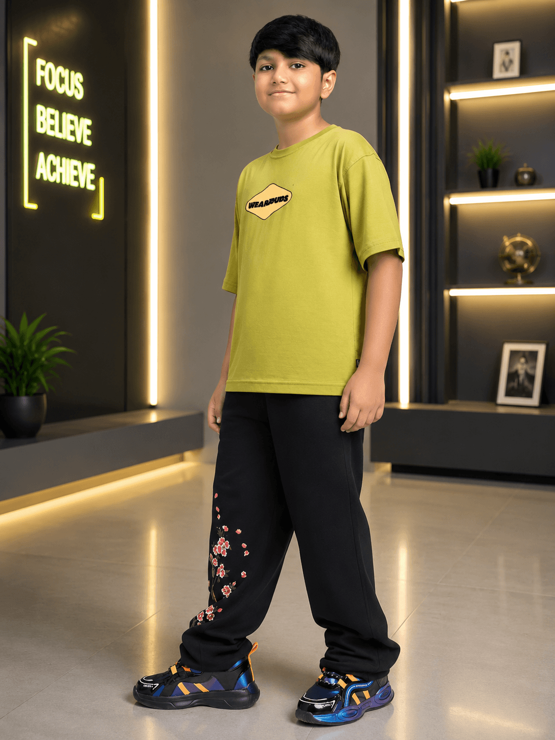BEAR ON BOARD CO-ORD FOR BOYS GIRLS OLIVE GREEN BLACK outfit displayed by a boy in olive t-shirt and black pants.