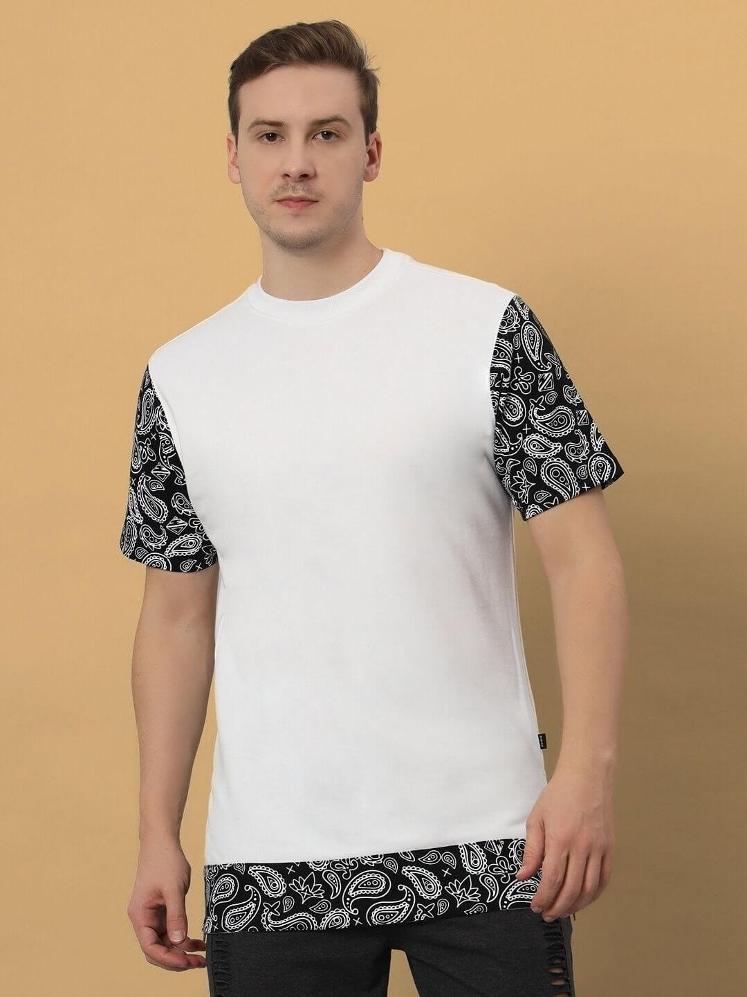 Man wearing a BEASLEY OVER-SIZED T-SHIRT WHITE with black patterned sleeves and hem, showcasing a trendy and casual fashion look.
