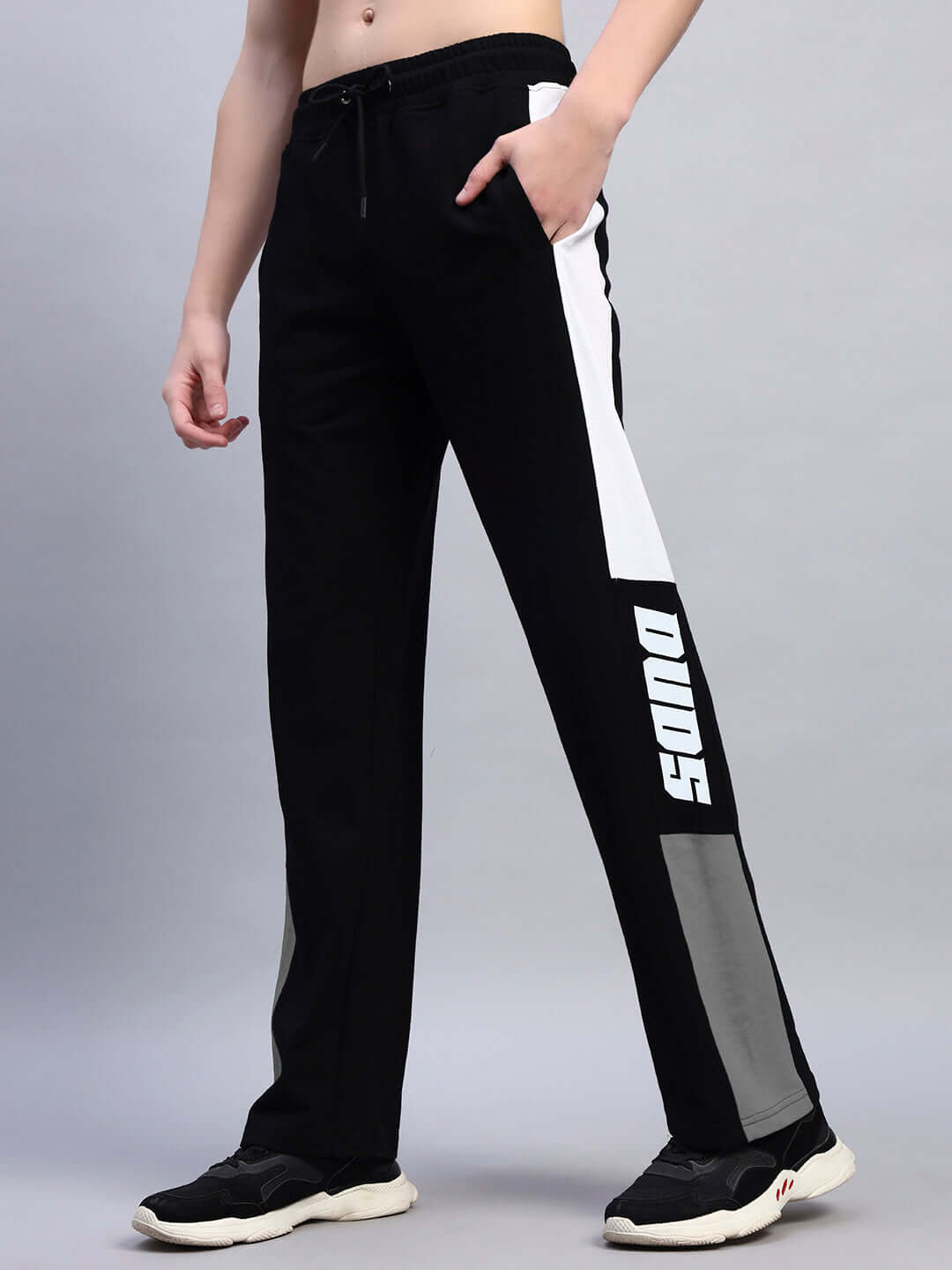 Person wearing black grey BELGIANS relaxed-fit joggers by DUDS, featuring a side stripe design. Made-to-order and customizable fit.