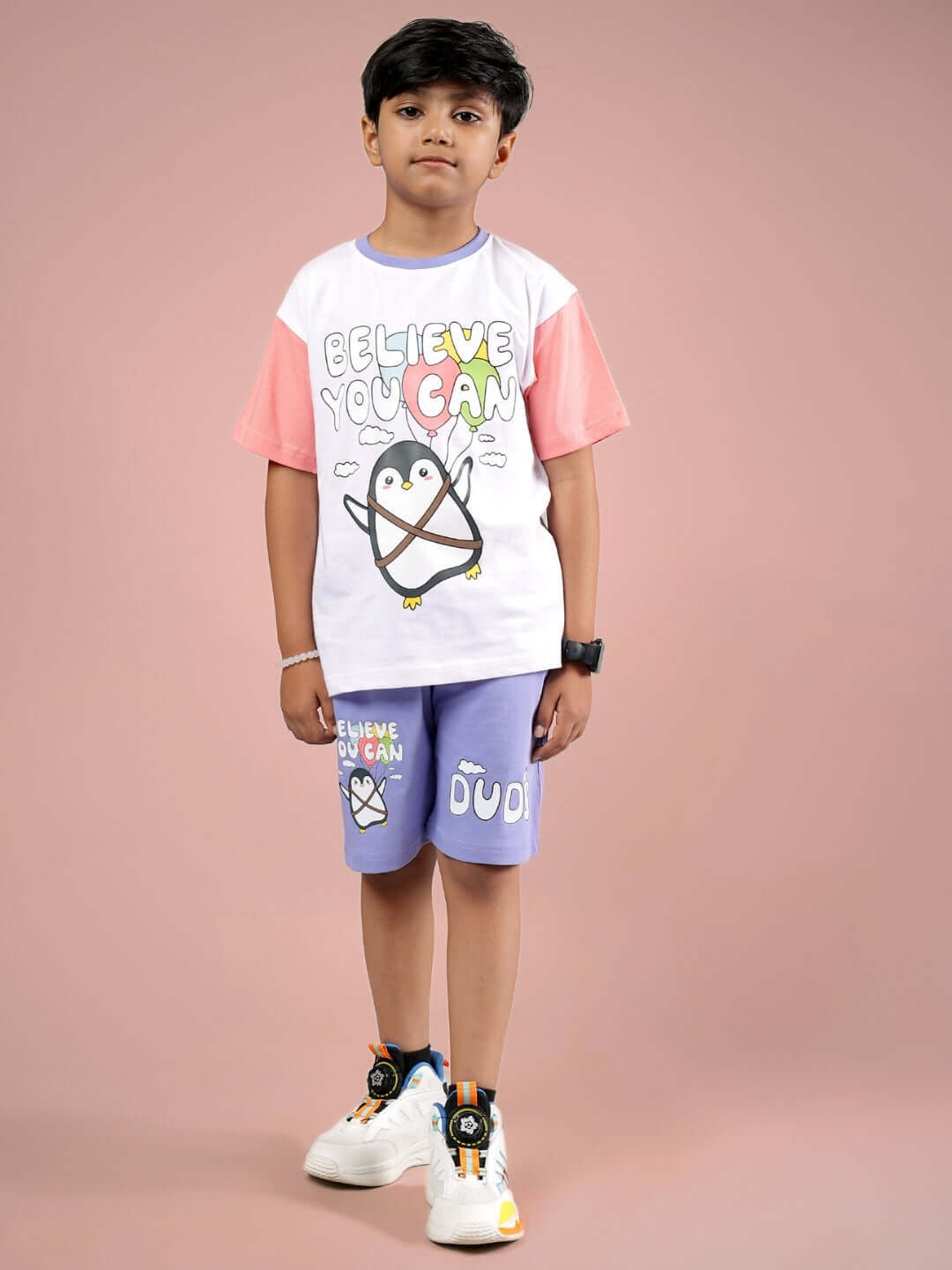 Child wearing BELIEVE CO-ORD set in white and lavender by DUDS, featuring a cute penguin graphic, perfect for boys and girls.