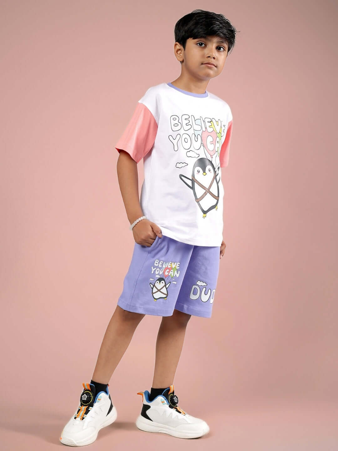 Child wearing BELIEVE CO-ORD set in white lavender by DUDS, featuring a fun penguin graphic, customizable for boys and girls.