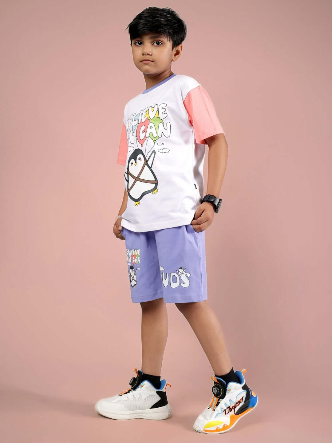 Boy wearing BELIEVE CO-ORD FOR BOYS & GIRLS WHITE LAVENDER, featuring a white t-shirt with pink sleeves and lavender shorts.