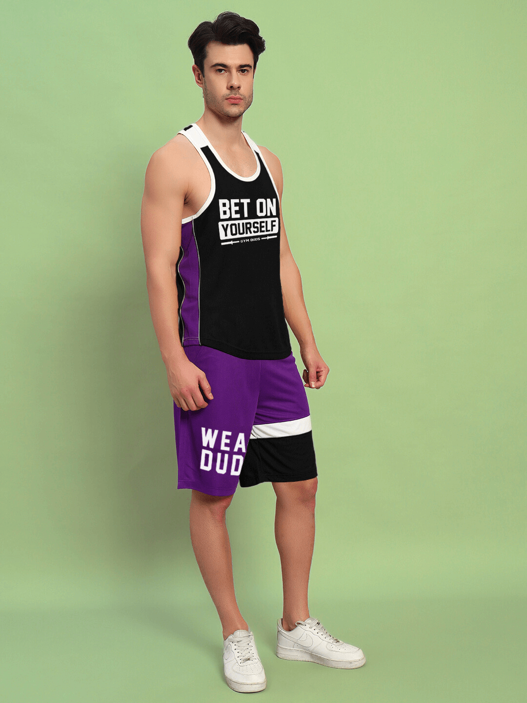 Model wearing Bet On Yourself gym co-ord set in black and purple, featuring a tank and matching shorts, ideal for workouts.