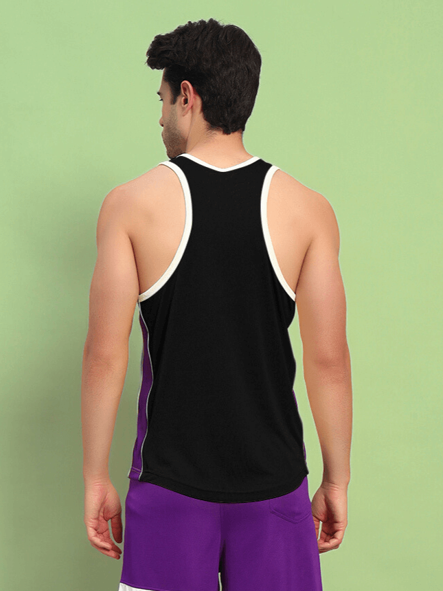 Man wearing black Bet On Yourself gym tank top with purple shorts in a gym setting.