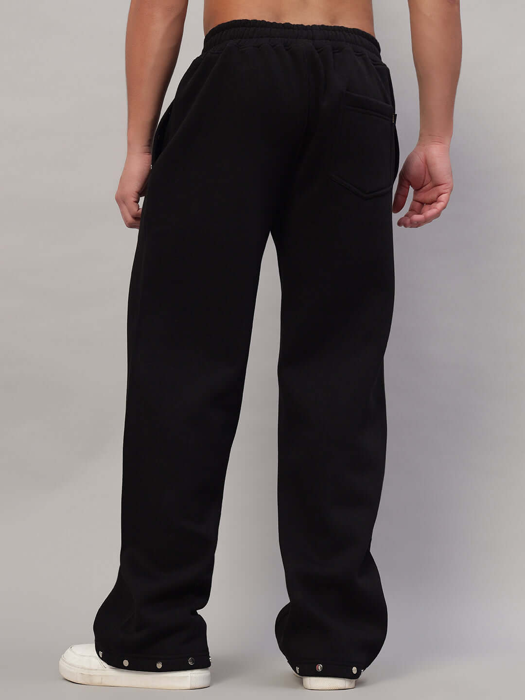 Back view of person wearing Global Cotton Fleece Jogger in black, showcasing loose fit and elastic waistband.
