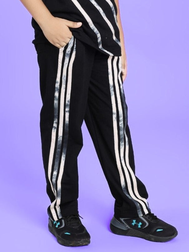 Child wearing FLICKER JOGGER FOR BOYS AND GIRLS BLACK with white stripes on purple background