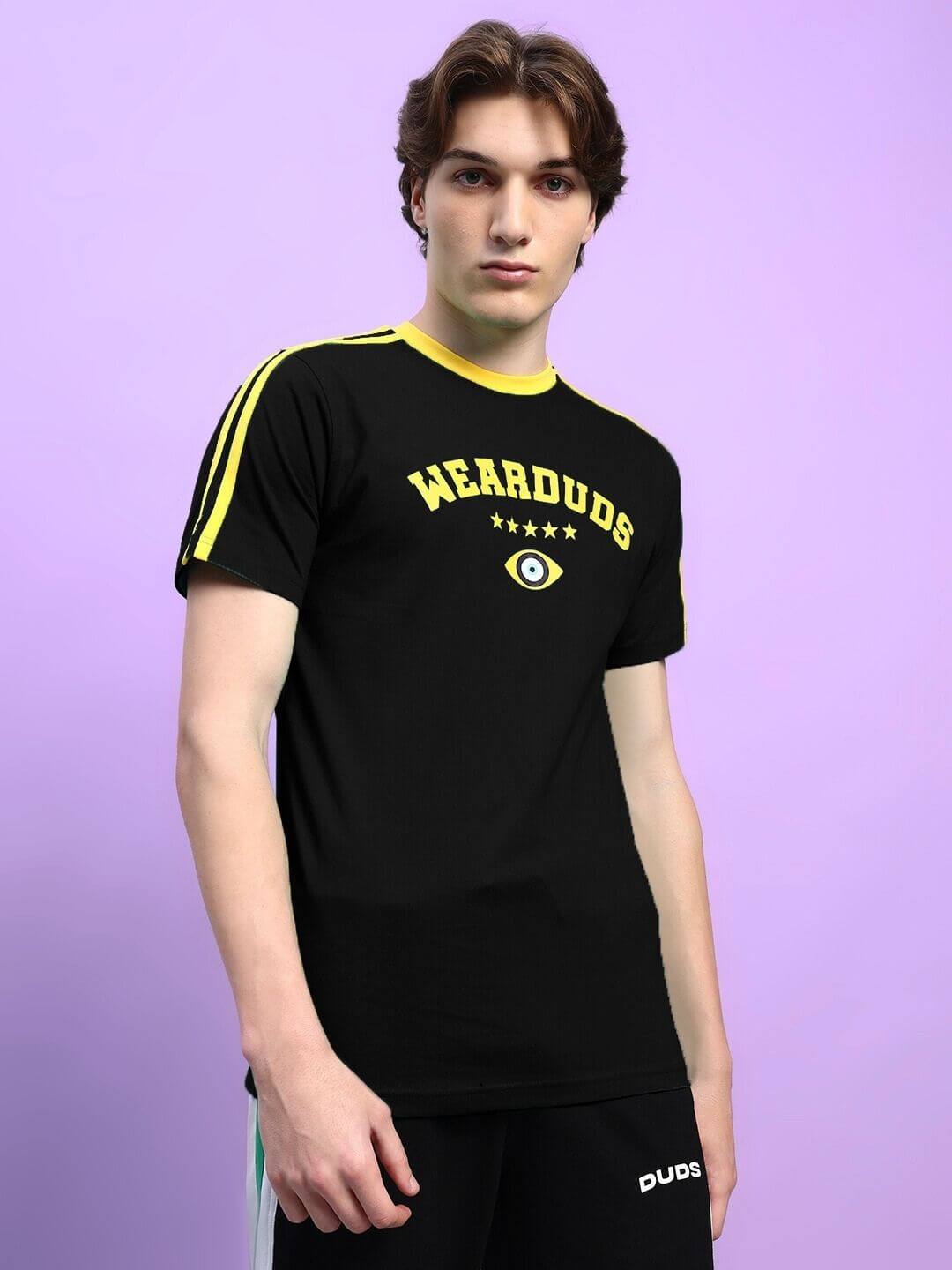 Model wearing Irish regular fit black T-shirt, 100% cotton, featuring striking graphics and yellow accents against a purple background.