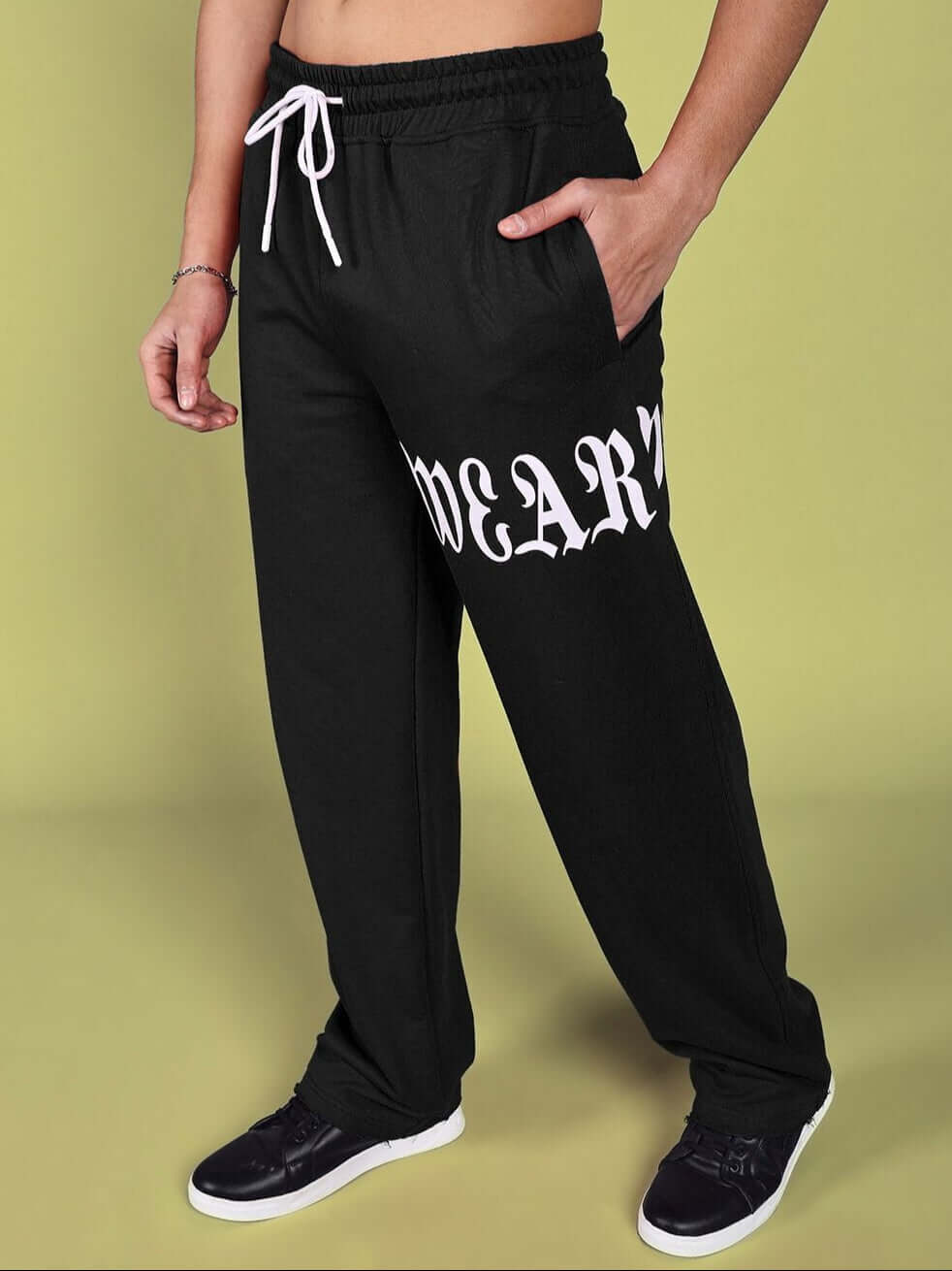 Man wearing Crimson Relaxed Fit Jogger in black with white drawstring, featuring bold lettering on the pant leg.