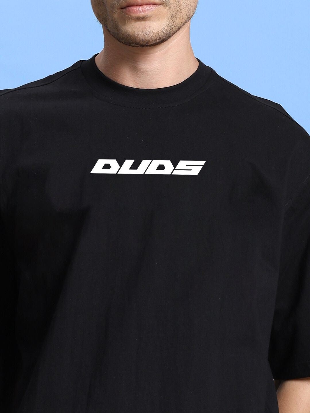 Man wearing black oversized t-shirt with bold graphic logo