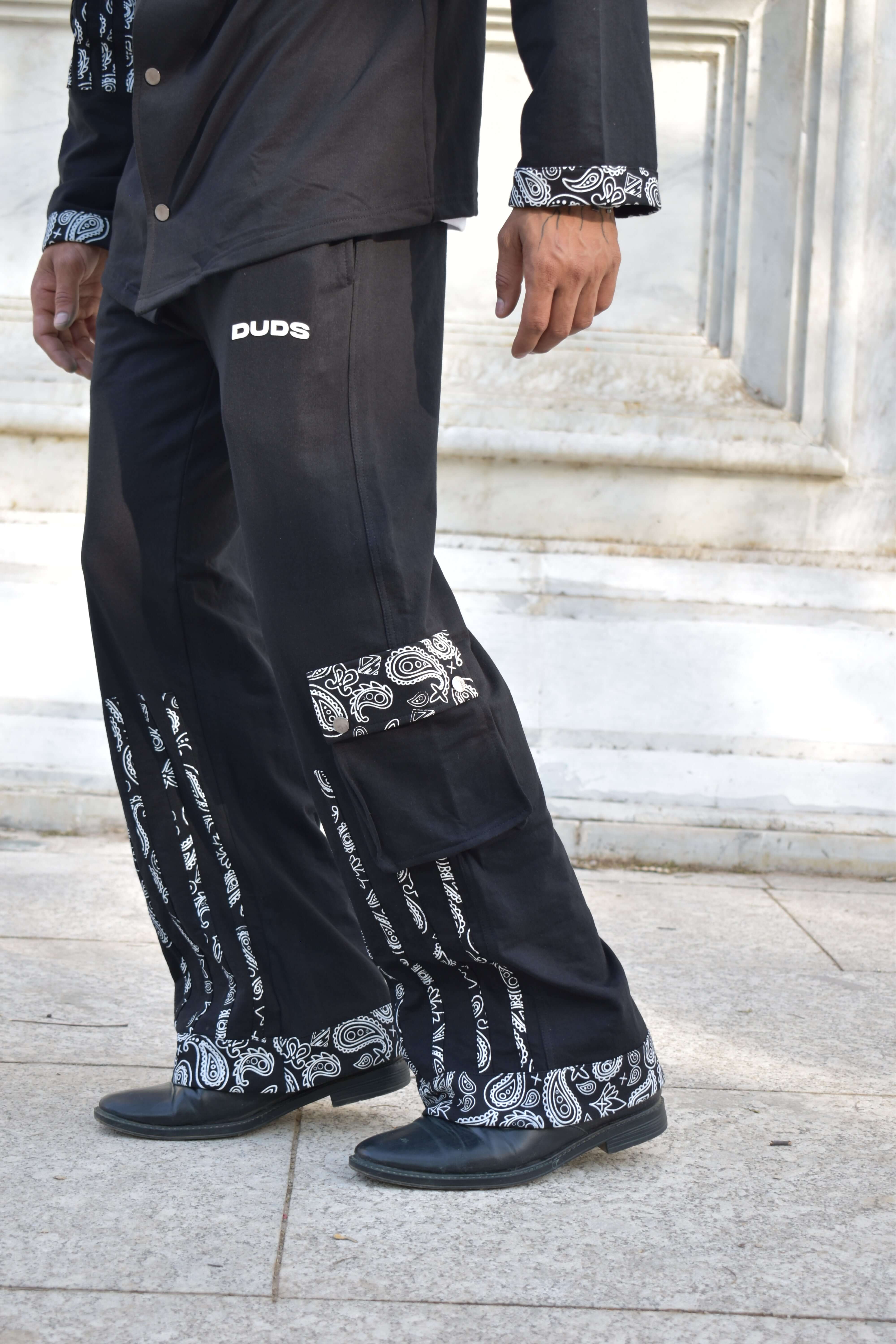 Man wearing Sanganeri black joggers with intricate design, made by DUDS, showcasing custom craftsmanship.
