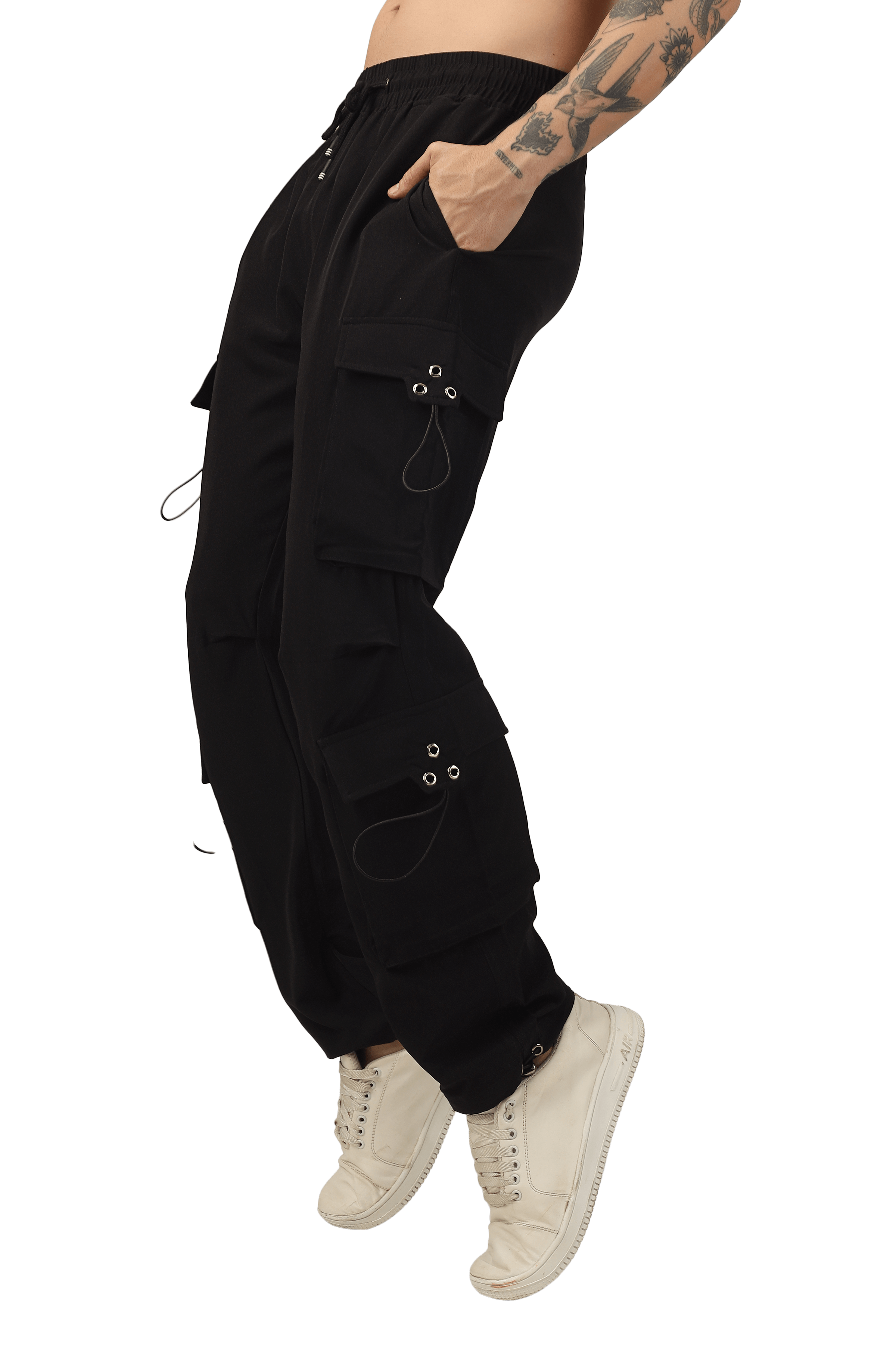 Person wearing black parachute cargo pants with white sneakers, highlighting pocket details and custom fit option.