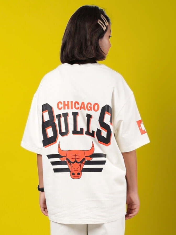 Child wearing oversized off-white Chicago Bulls T-shirt with logo, facing away on a yellow background.
