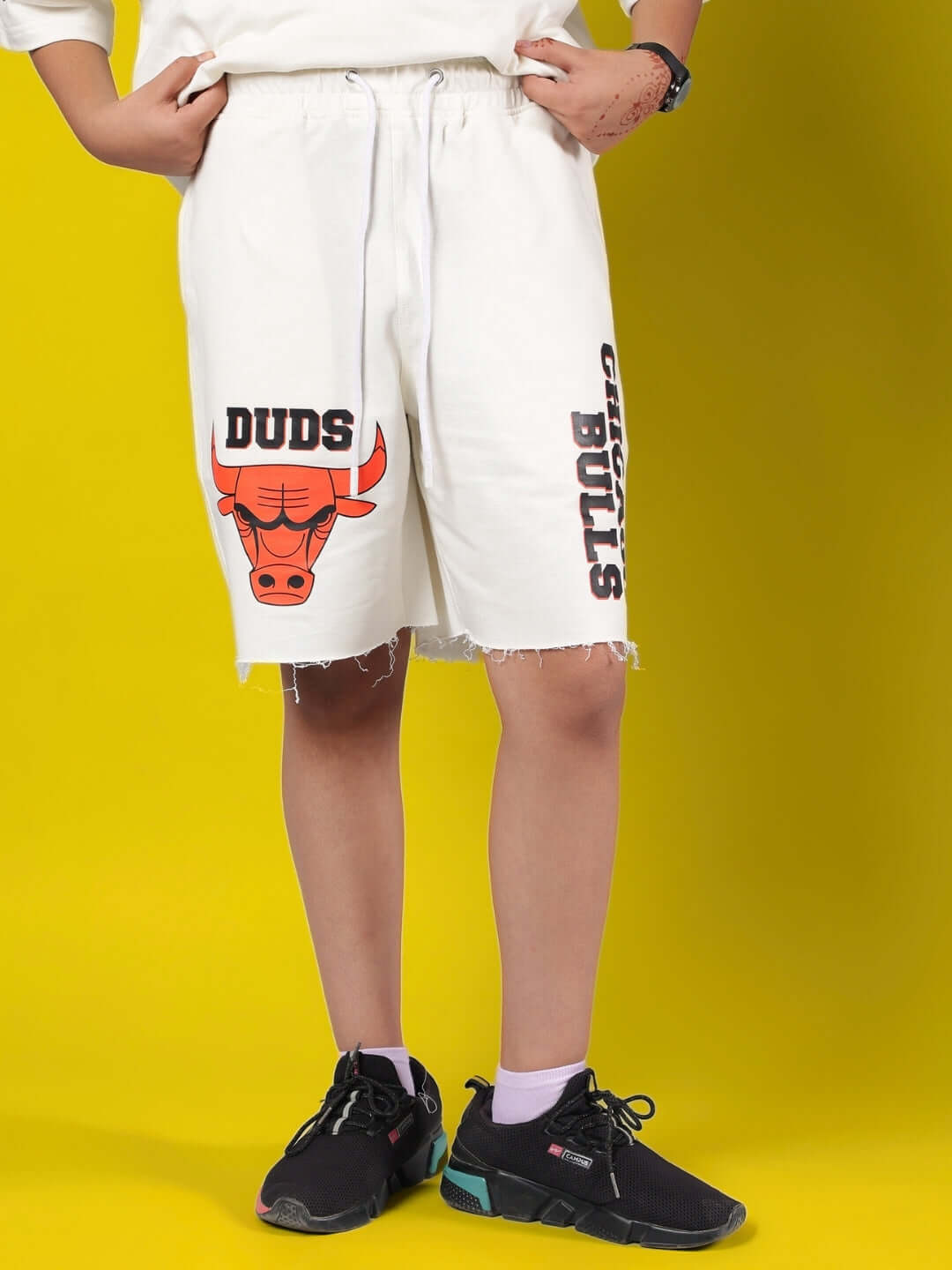 Child wearing off-white Blaze Bulls shorts with a colorful bull design, made by DUDS. Suitable for boys and girls, customizable sizing available.