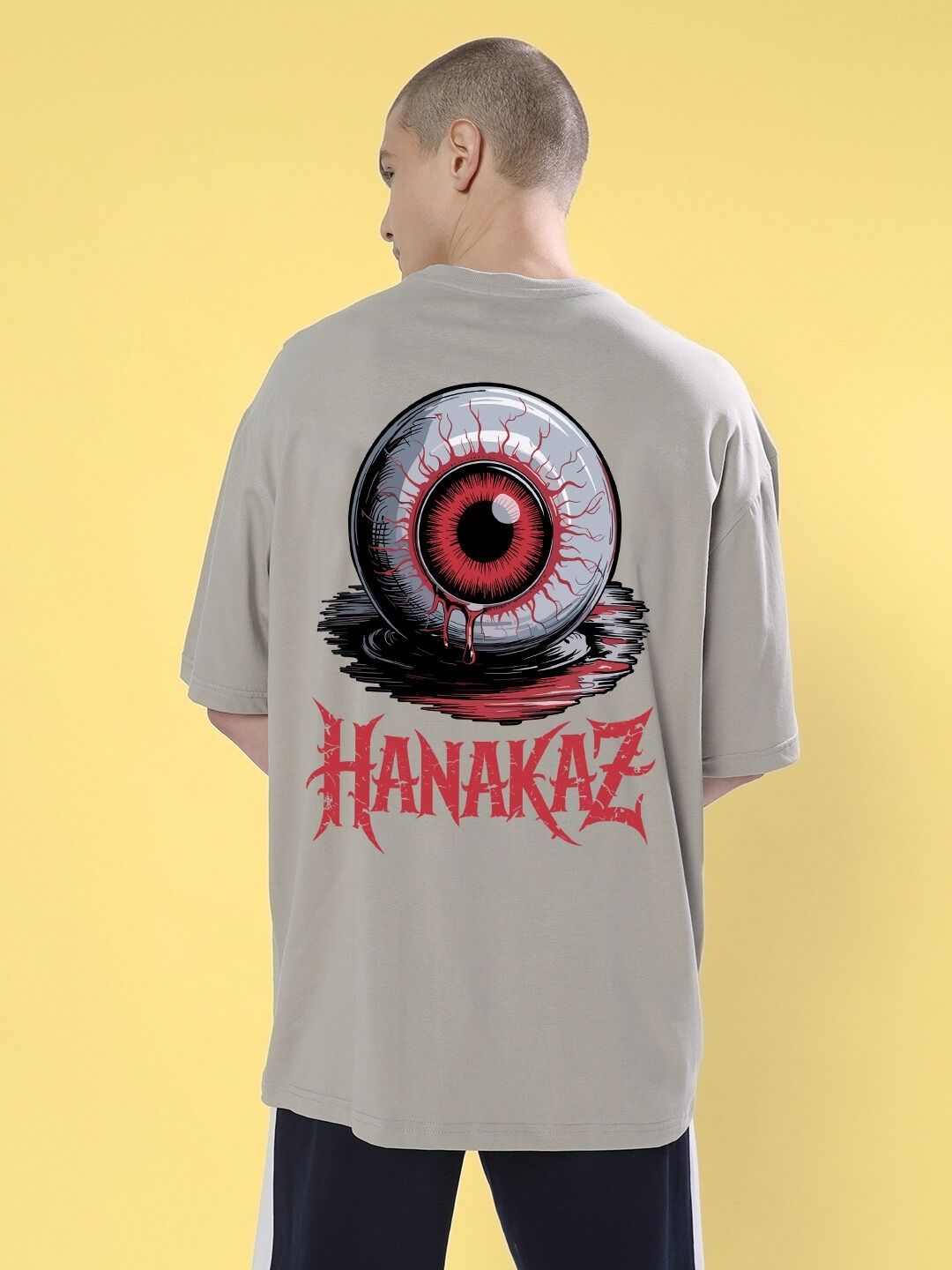 Back view of BLOODY EYE OVER-SIZED T-SHIRT GREY with graphic design on yellow background.