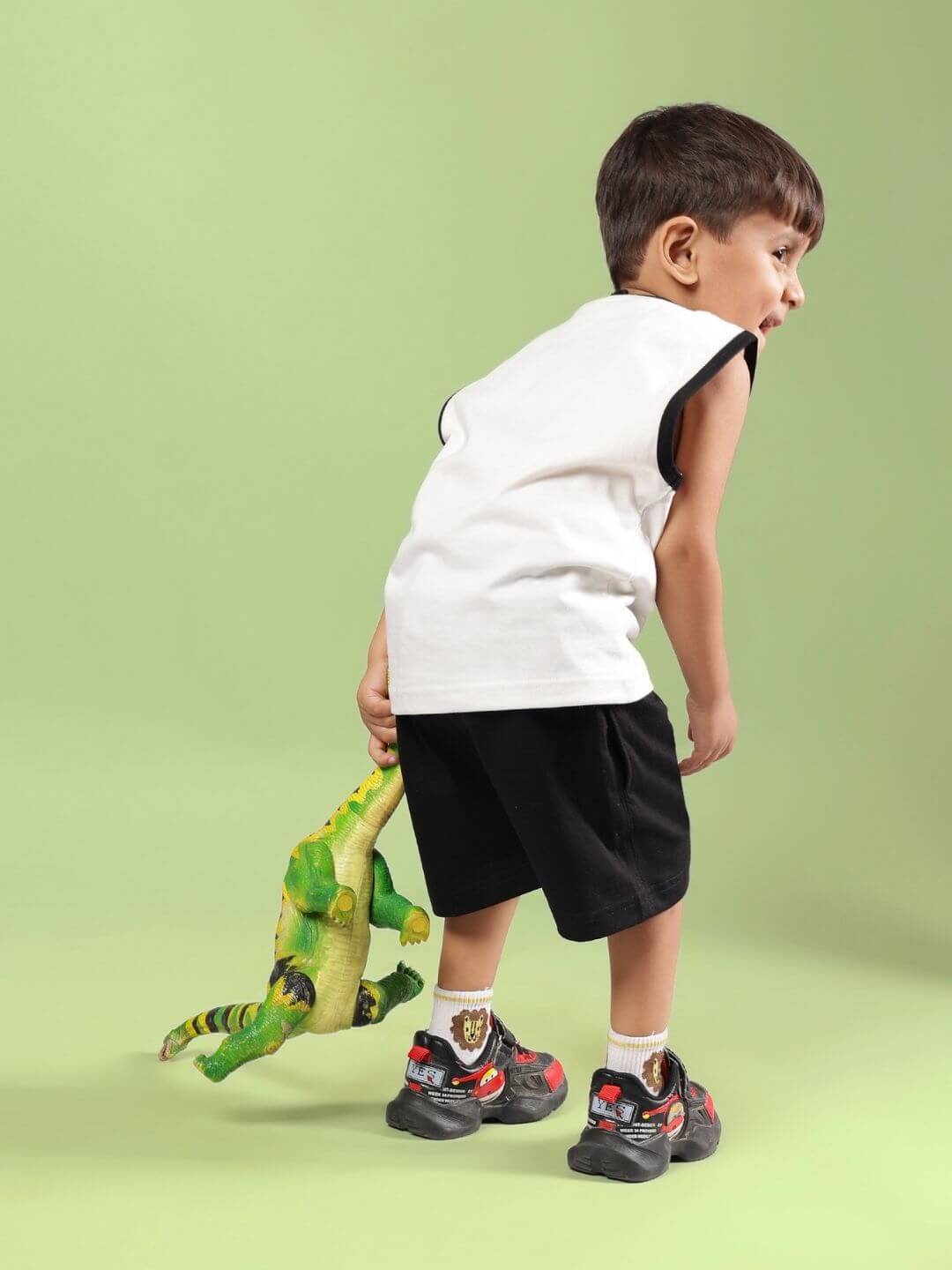 Child in BLUE CAT SUMMER CO-ORD FOR BOYS AND GIRLS OFF WHITE-BLACK holding a toy dinosaur, showcasing the comfy kids' set.
