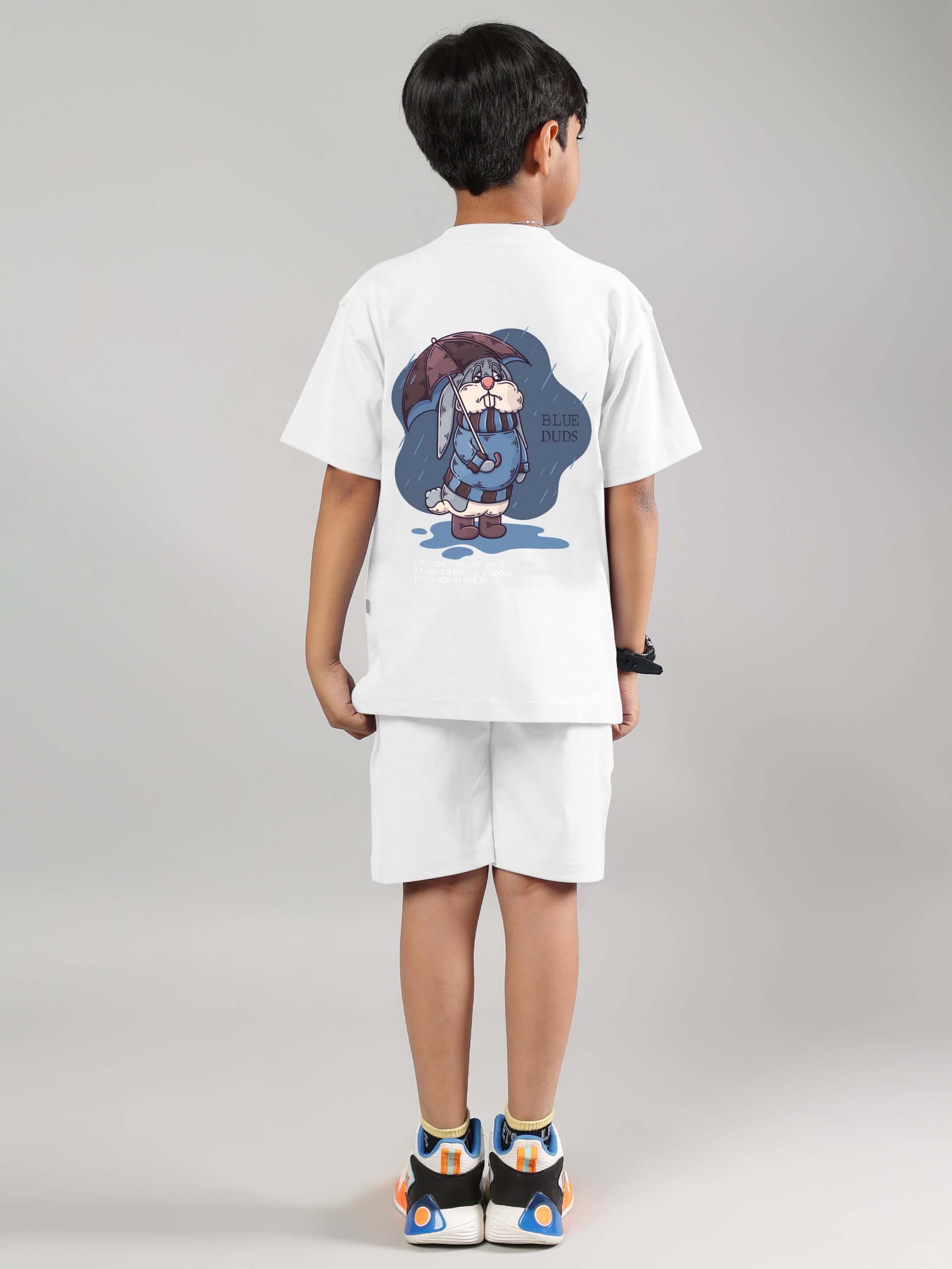 Child wearing a BLUE LAPIN CO-ORD FOR BOYS GIRLS WHITE set featuring a playful graphic on the back, made from 100% cotton for comfort.