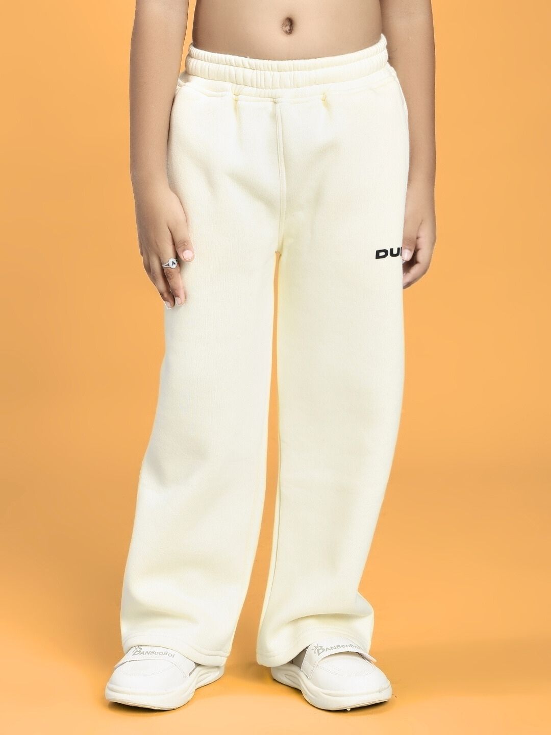 Child wearing BLUE OCEAN WORLD FLEECE JOGGER FOR BOYS AND GIRLS OFF-WHITE with elastic waistband and casual fit.