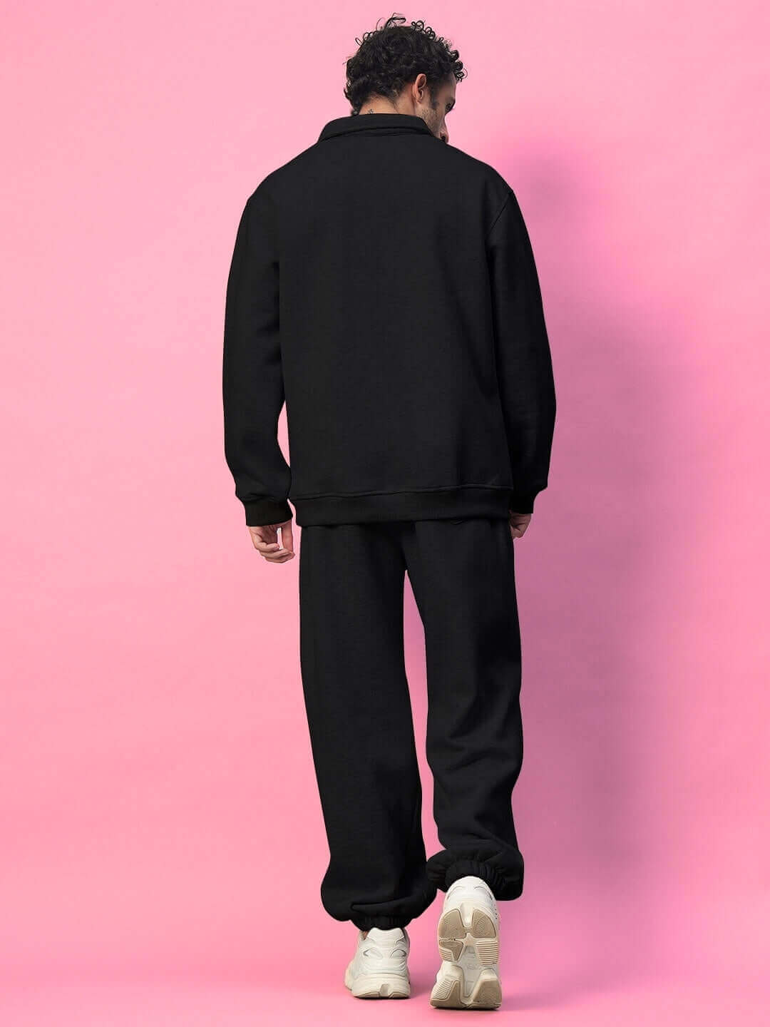 Model wearing BONA-FIDE Cotton Fleece Pant in black, showcasing soft, comfortable design against a pink background.
