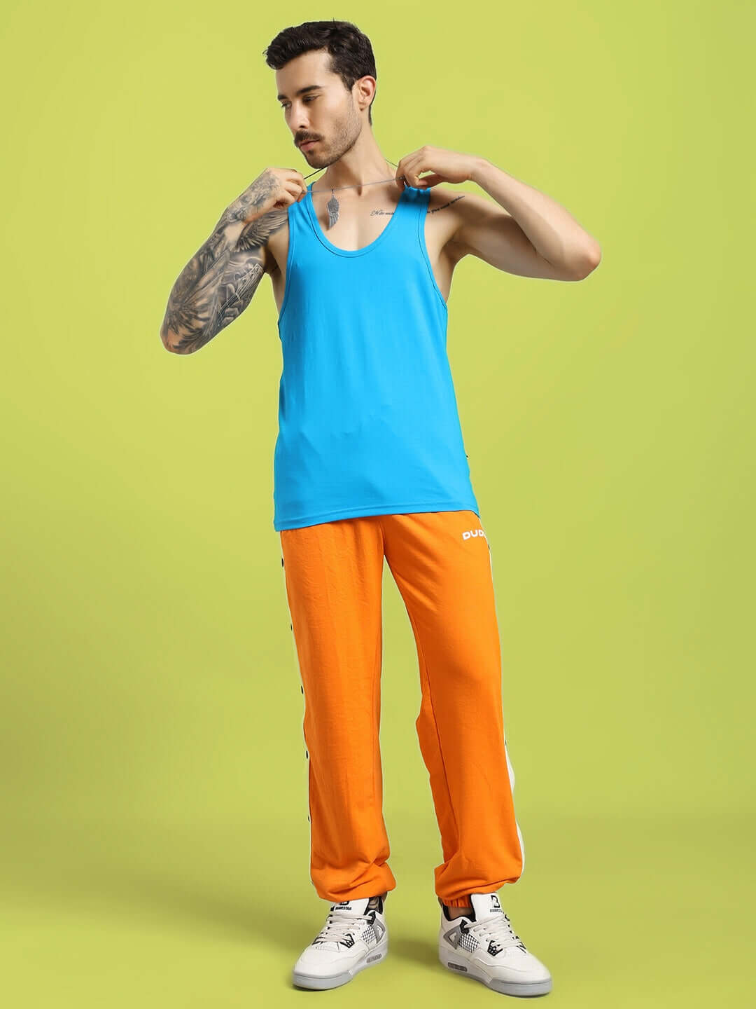 Man wearing a bright blue Bonny Gym T-shirt with orange pants, showcasing casual athletic wear.