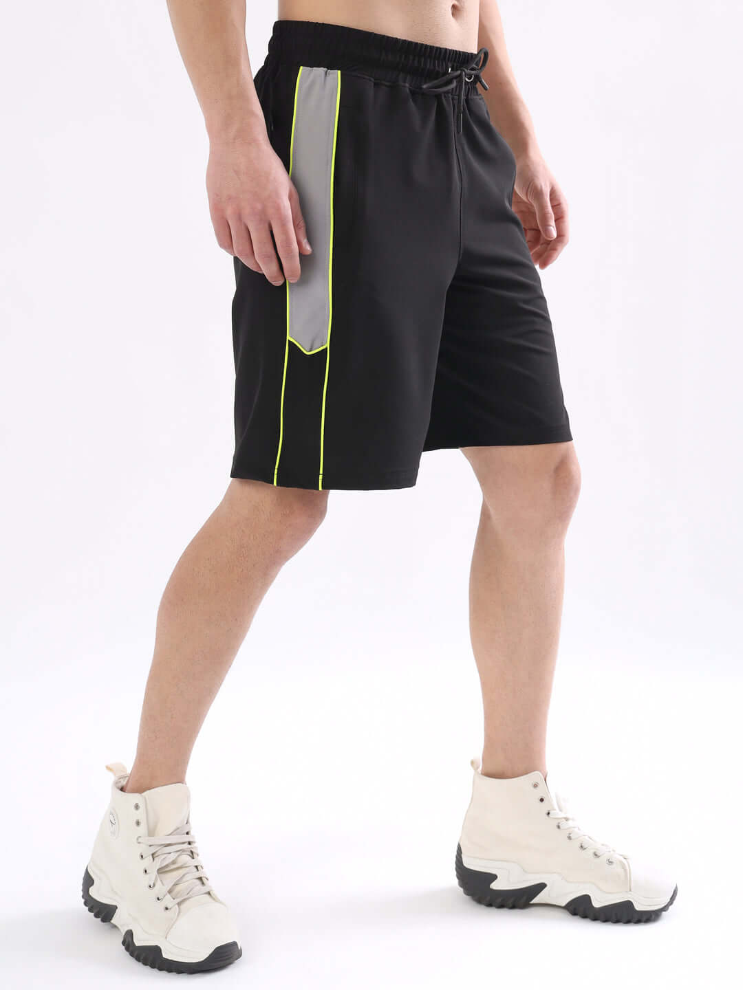 Black shorts with neon green piping, shown with white sneakers. Adjustable fit option available. Customizable, handmade from DUDS.