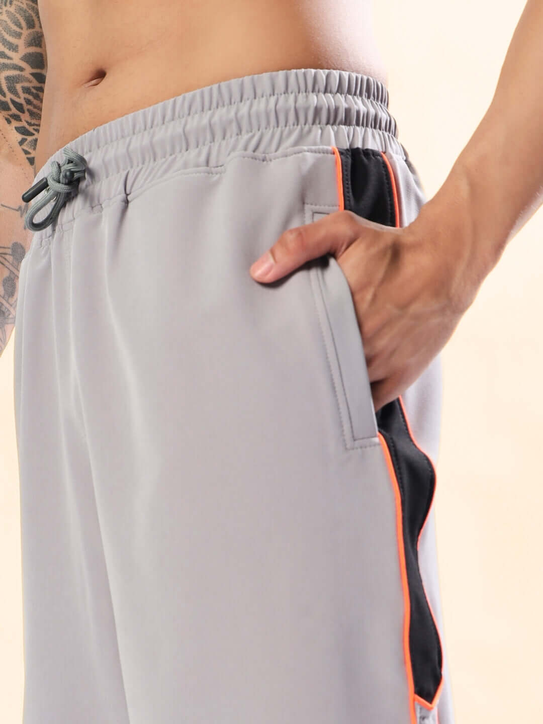 BOOMER SHORTS GREY WITH ORANGE PIPING showcasing comfortable casual wear with vibrant orange accents.