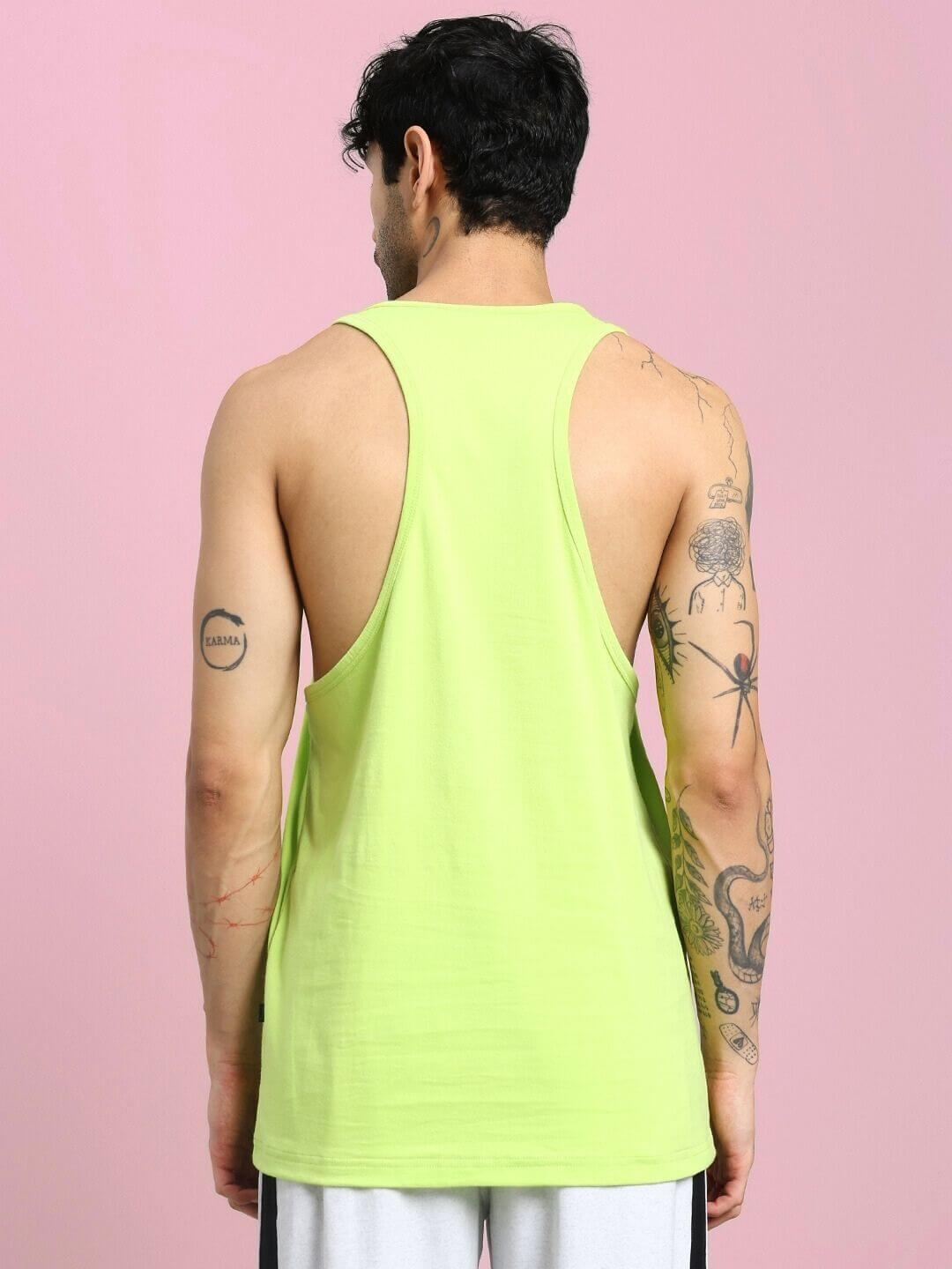 Back view of a man wearing a BORN TO MAKE HISTORY GYM VEST T-SHIRT NEON GREEN, showcasing its bold color and sleeveless design.