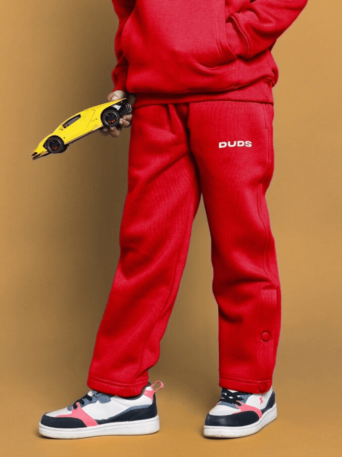 Red jogger pants for boys and girls with a toy car, BORN TO SHINE collection.