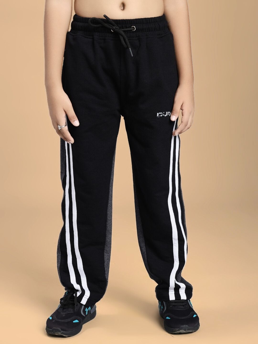 Child wearing BOSCO STRIPE CO-ORD SET FOR BOYS AND GIRLS BLACK DARK GREY with striped joggers.