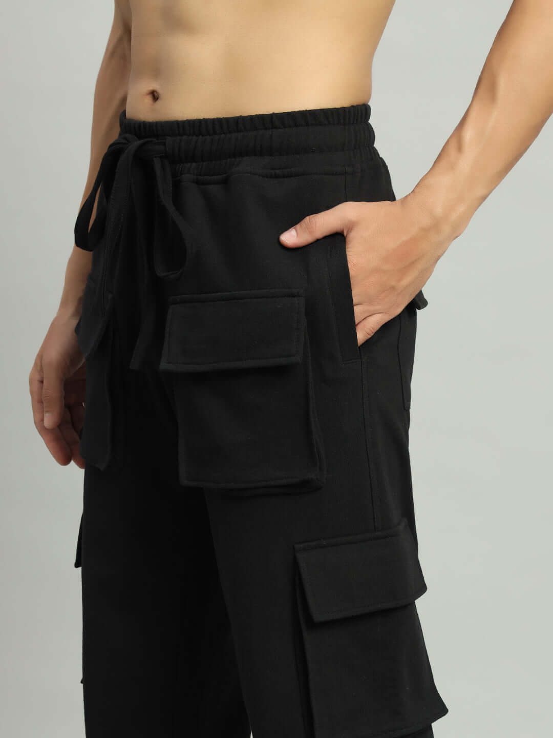 Man wearing black BRACE 8 Pocket Cargo Pant, showcasing multiple utility pockets and adjustable waist, crafted by DUDS.