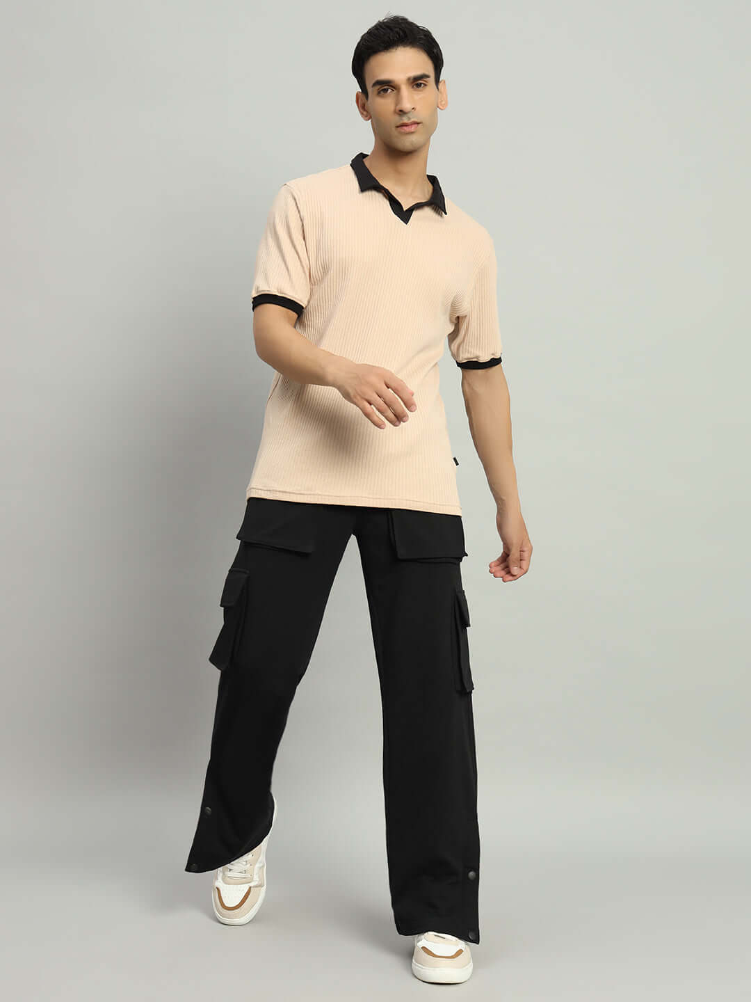 Man wearing BRACE 8 Pocket Cargo Pant in black, paired with a beige shirt, showcasing a stylish and casual look.