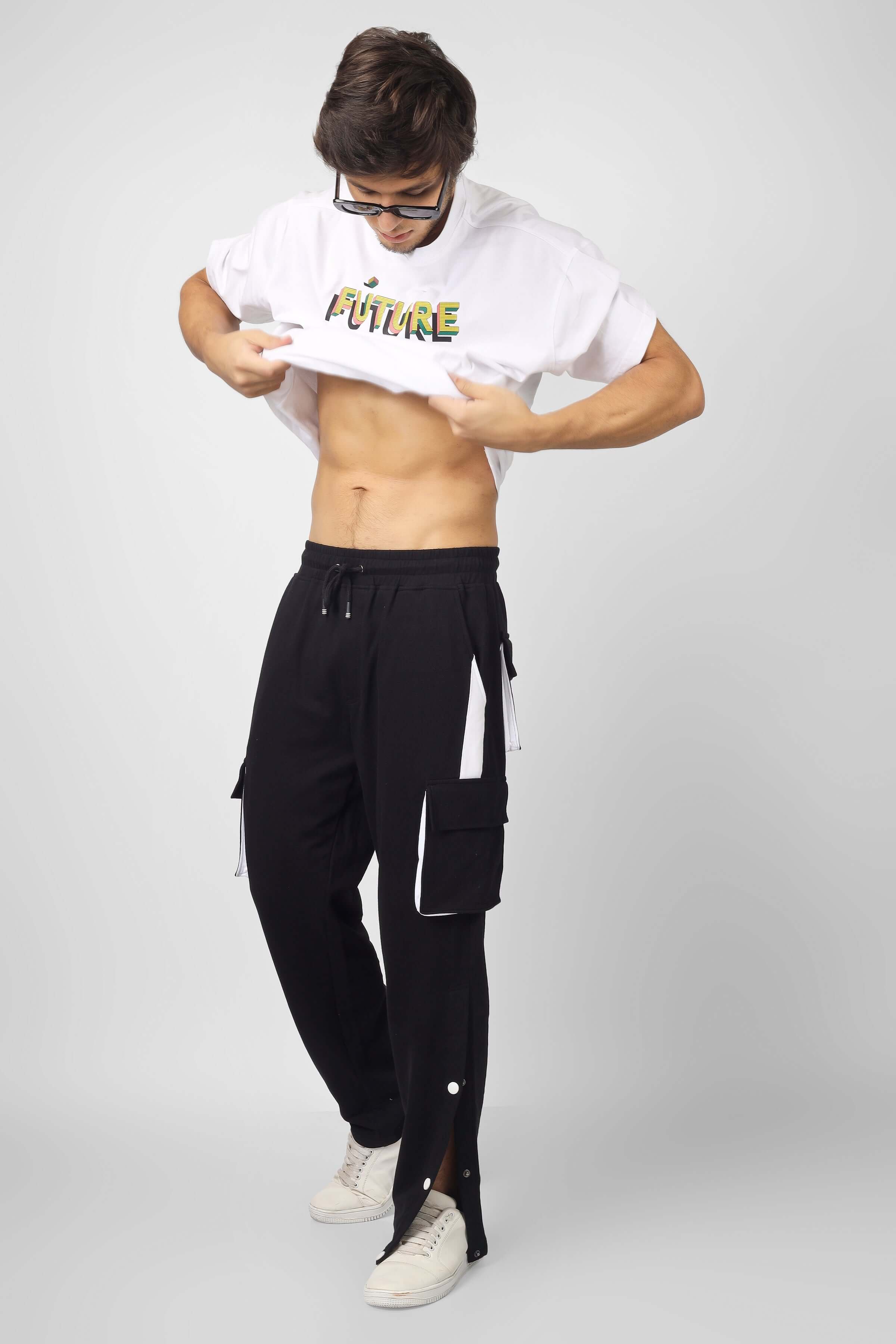 Man wearing black and white Bracket Cargo Pants with a white T-shirt, showcasing stylish, customizable apparel from DUDS.