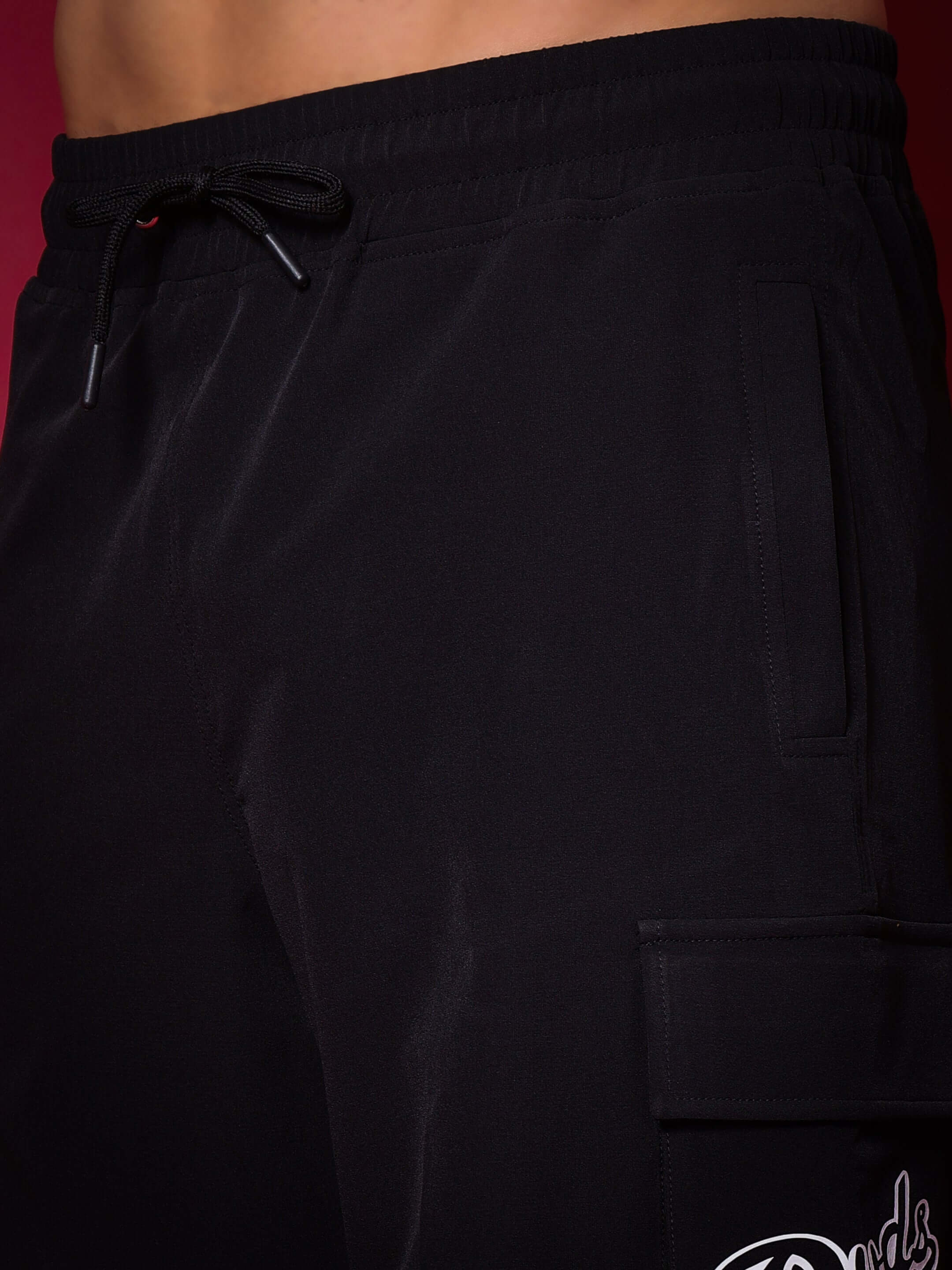 Close-up of black Brawny Cargo Shorts featuring adjustable drawstring and side pockets for versatile style and custom fit options.
