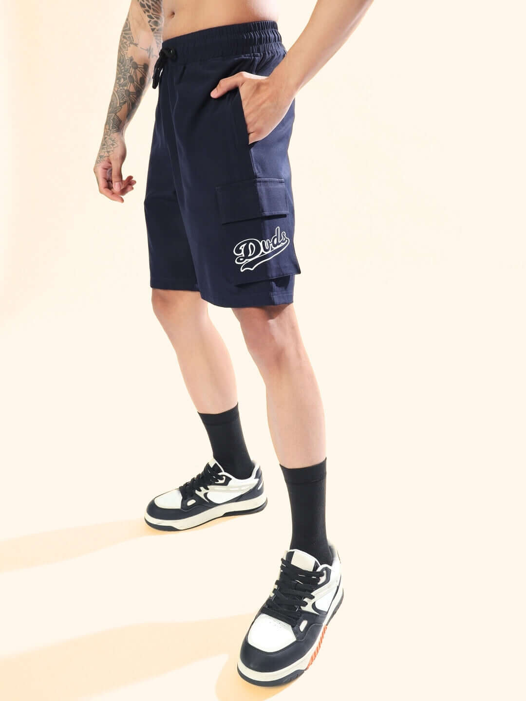 Brawny Navy Blue Cargo Shorts by Duds, featuring spacious pockets, ideal for custom fit options. Styled with sneakers and black socks.