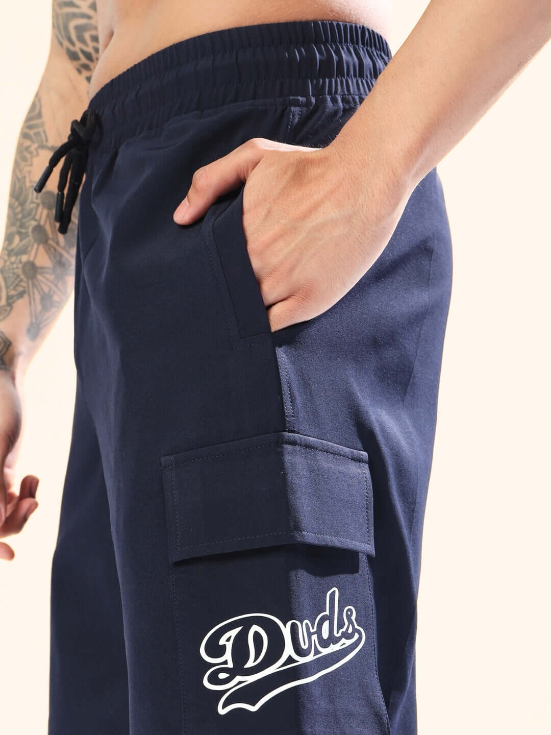 Navy blue Brawny cargo shorts by Duds, featuring a logo and side pocket, ideal for customizable fit options.