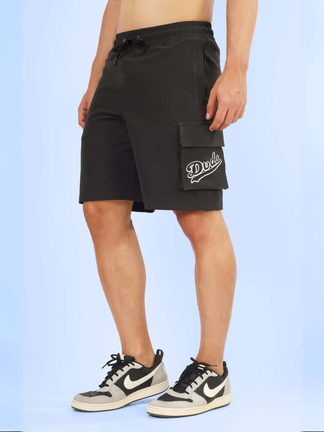 Brawny cargo shorts in dark grey by DUDS, featuring a customizable fit option for personalized comfort, modeled with sneakers.