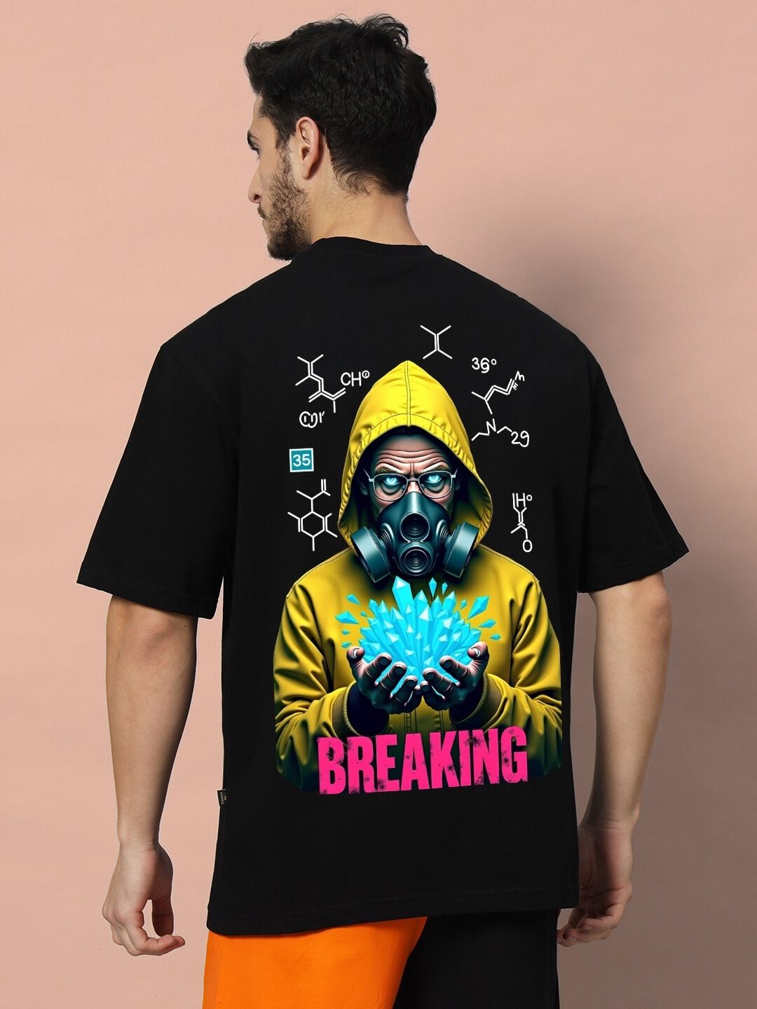 Man wearing a BREAKING OVER-SIZED T-SHIRT BLACK with graphic design on the back.
