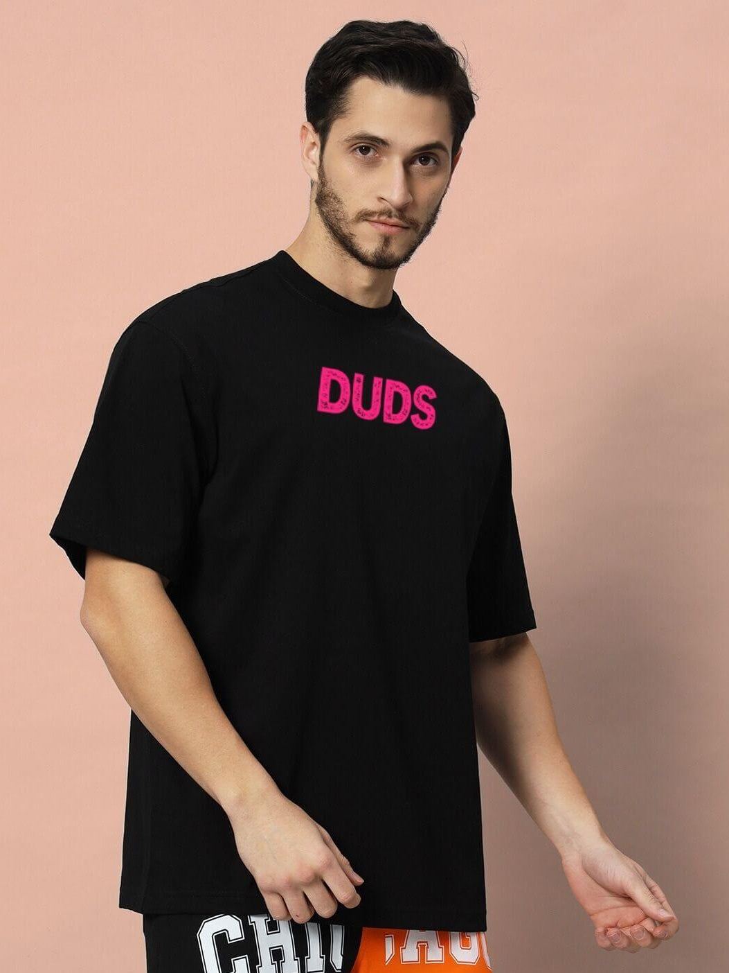 Model wearing BREAKING OVER-SIZED T-SHIRT BLACK with streetwear style, showcasing relaxed silhouette in a casual pose.