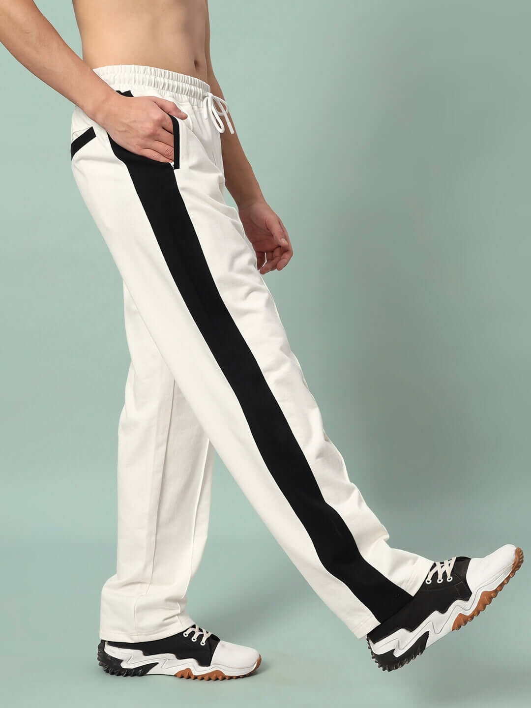 Model wearing Breezer Side Contrast Joggers in off-white and black, showcasing the side stripe design and comfortable fit.