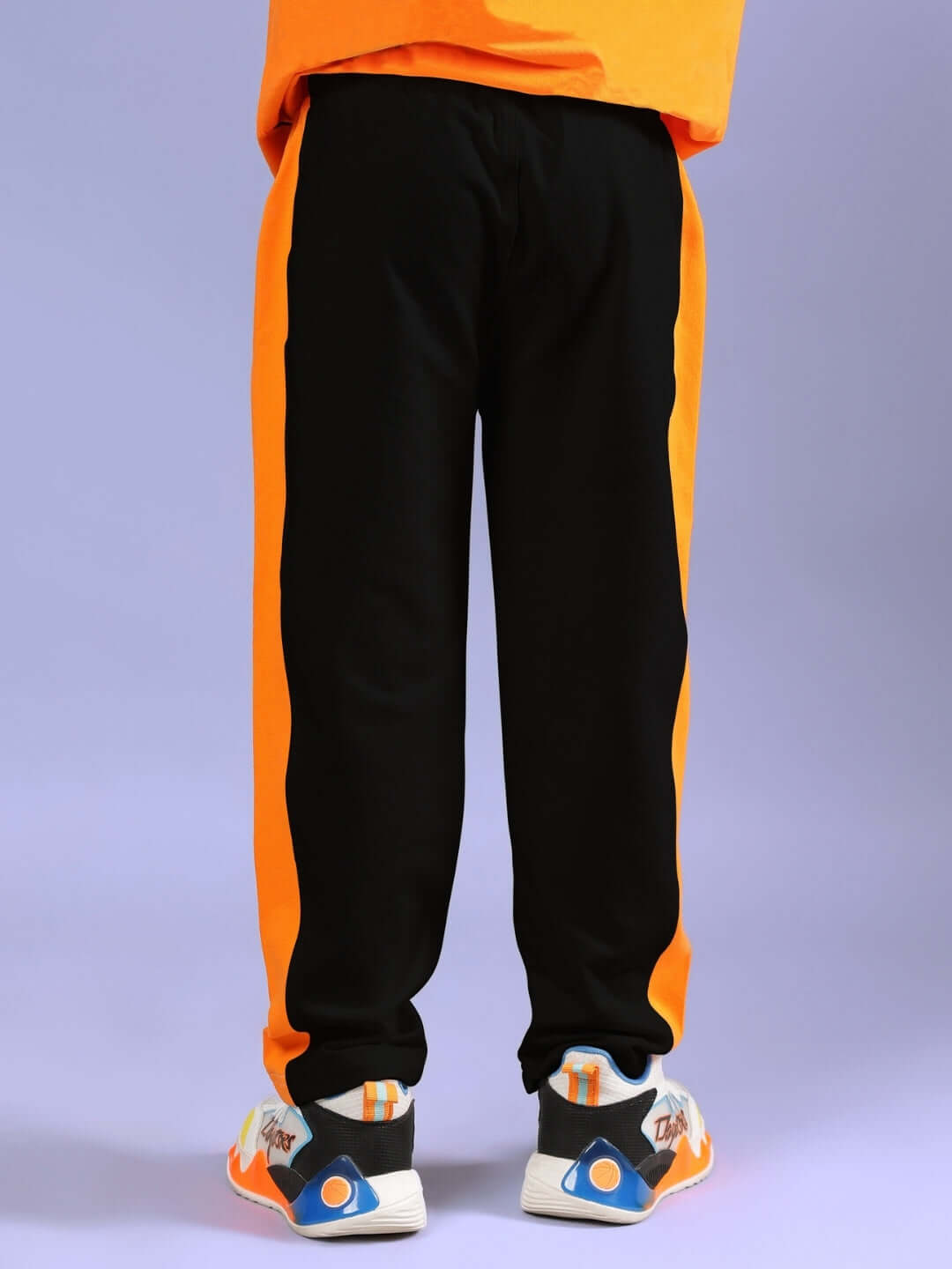 Child wearing BREEZER Jogger, black and orange design, suitable for boys and girls, by DUDS.