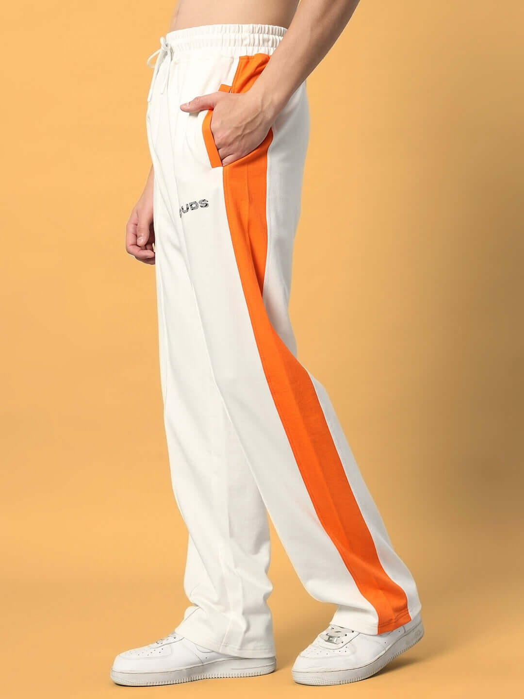 Model wearing Breezer Side Contrast Joggers in off-white with orange stripe, made-to-order by DUDS. Perfect for custom fit options.
