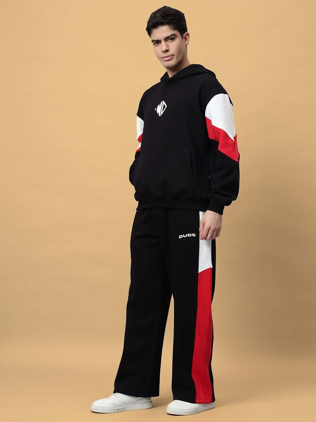Model wearing BRIO FLEECE COLORBLOCK CO-ORD BLACK, featuring colorblock design in red, white, and black for modern streetwear style.