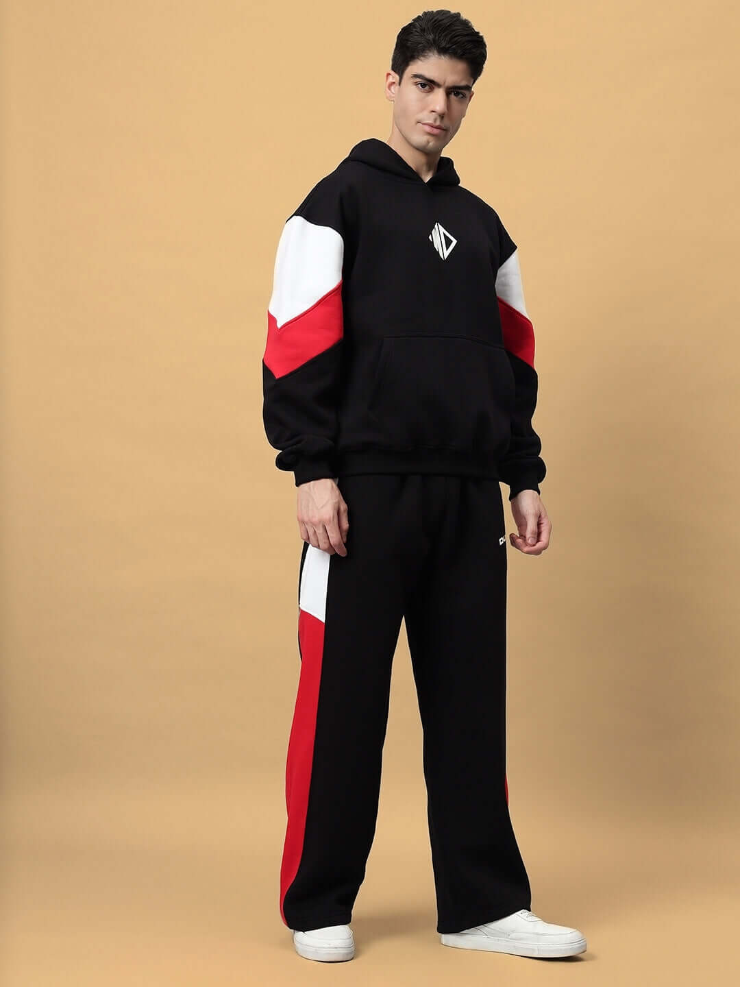 Model wearing BRIO FLEECE COLORBLOCK CO-ORD BLACK, featuring a modern streetwear style with red and white colorblock design on black fleece.