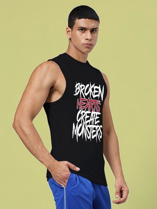 BROKEN HEART PRINT SLEEVELESS T-SHIRT BLACK with bold graphic design on a male model against a light background.