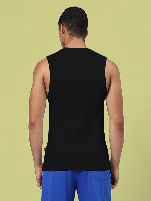 Back view of BROKEN HEART PRINT SLEEVELESS T-SHIRT BLACK on male model, showcasing sleeveless design.