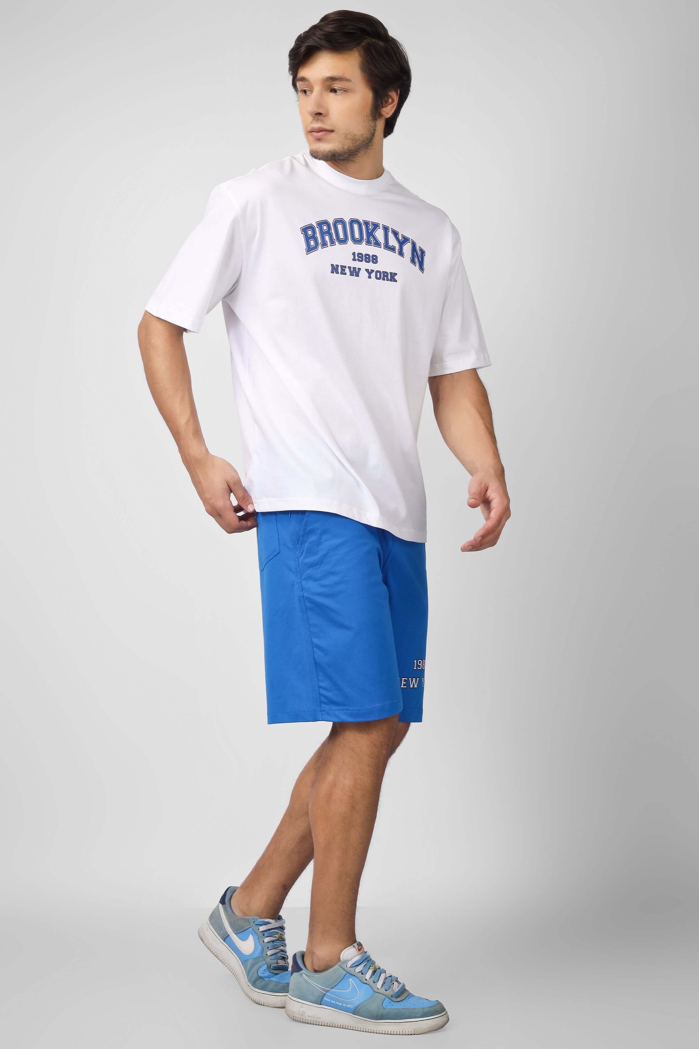 Model wearing BROOKLYN CO-ORD SET in white and blue, featuring custom fit options and handmade quality for prepaid orders.