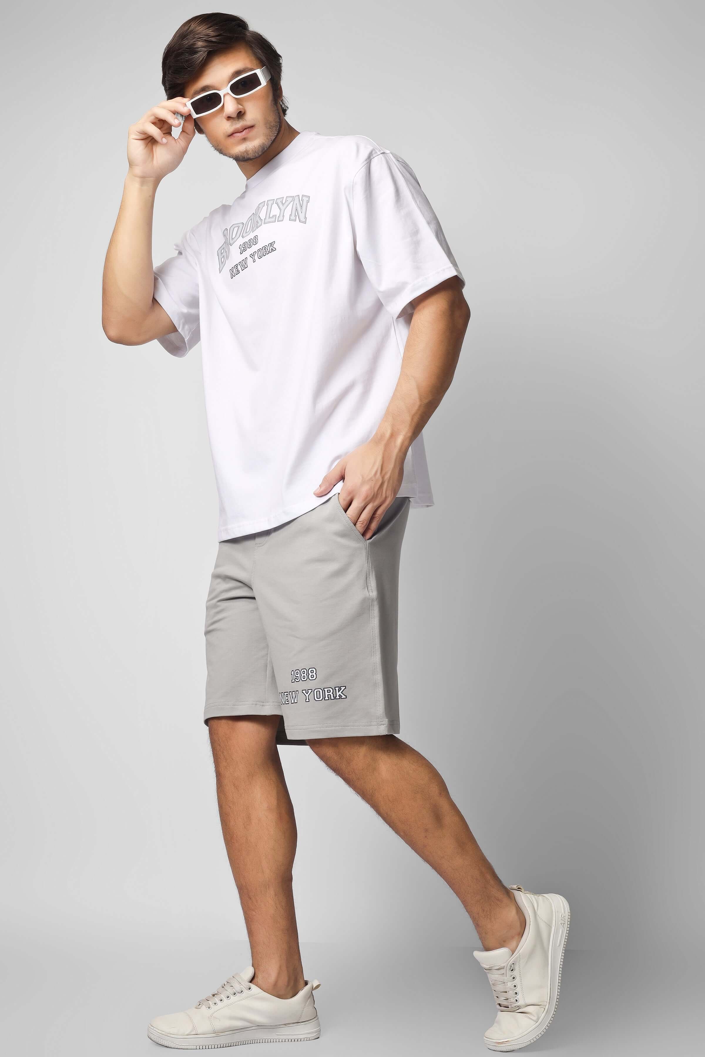 Man wearing the stylish Brooklyn Co-Ord Set in white and grey, featuring a casual shirt and shorts, perfect for a modern, relaxed look.
