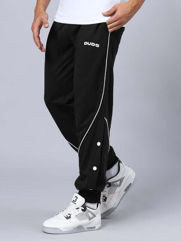 Model wearing BROSSFINE contrast joggers in black by DUDS, showcasing sleek design and custom fit options. Prepaid orders only.